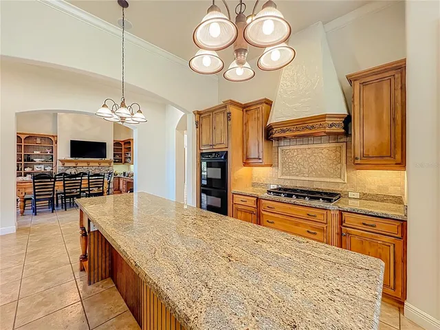 a view of an empty room with wooden floor and a ceiling fan