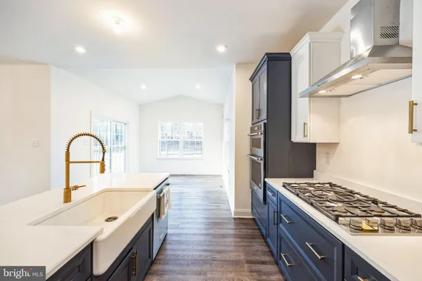 a large kitchen with stainless steel appliances granite countertop a lot of counter space and wooden floors