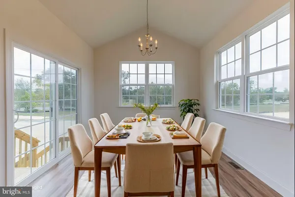 a dining room with furniture large windows and wooden floor