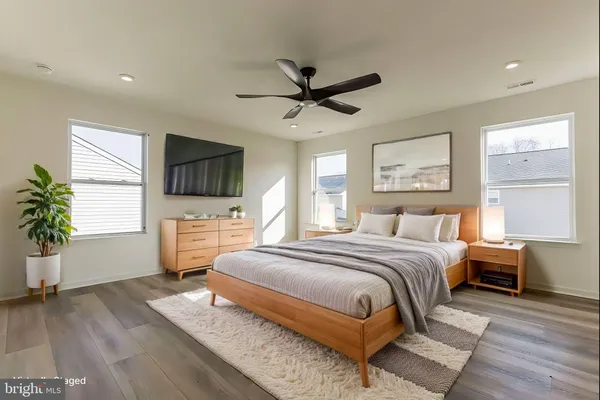 a spacious bedroom with a bed and a flat screen tv