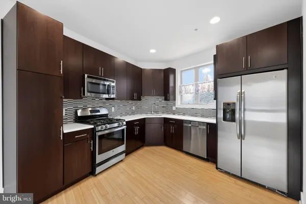 a kitchen with granite countertop stainless steel appliances and wooden cabinets