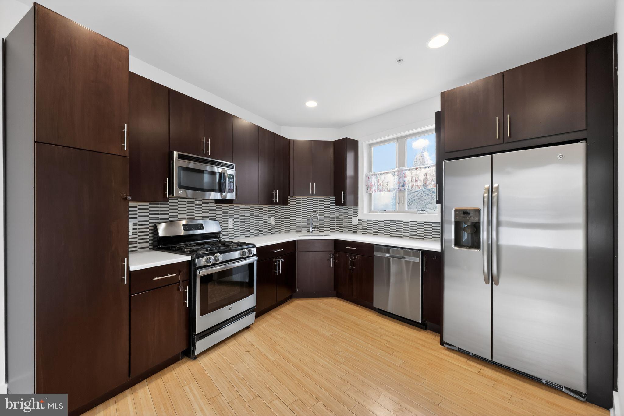 920 North Front Street Philadelphia, PA 19123 - Photo 5 of 28 a kitchen with granite countertop stainless steel appliances and wooden cabinets