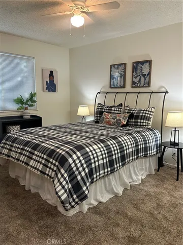 a bedroom with a bed and painting on the wall