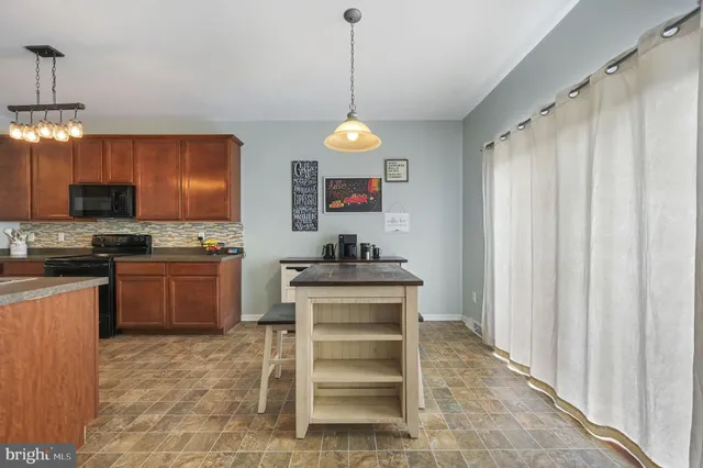 a kitchen with a refrigerator and a stove top oven