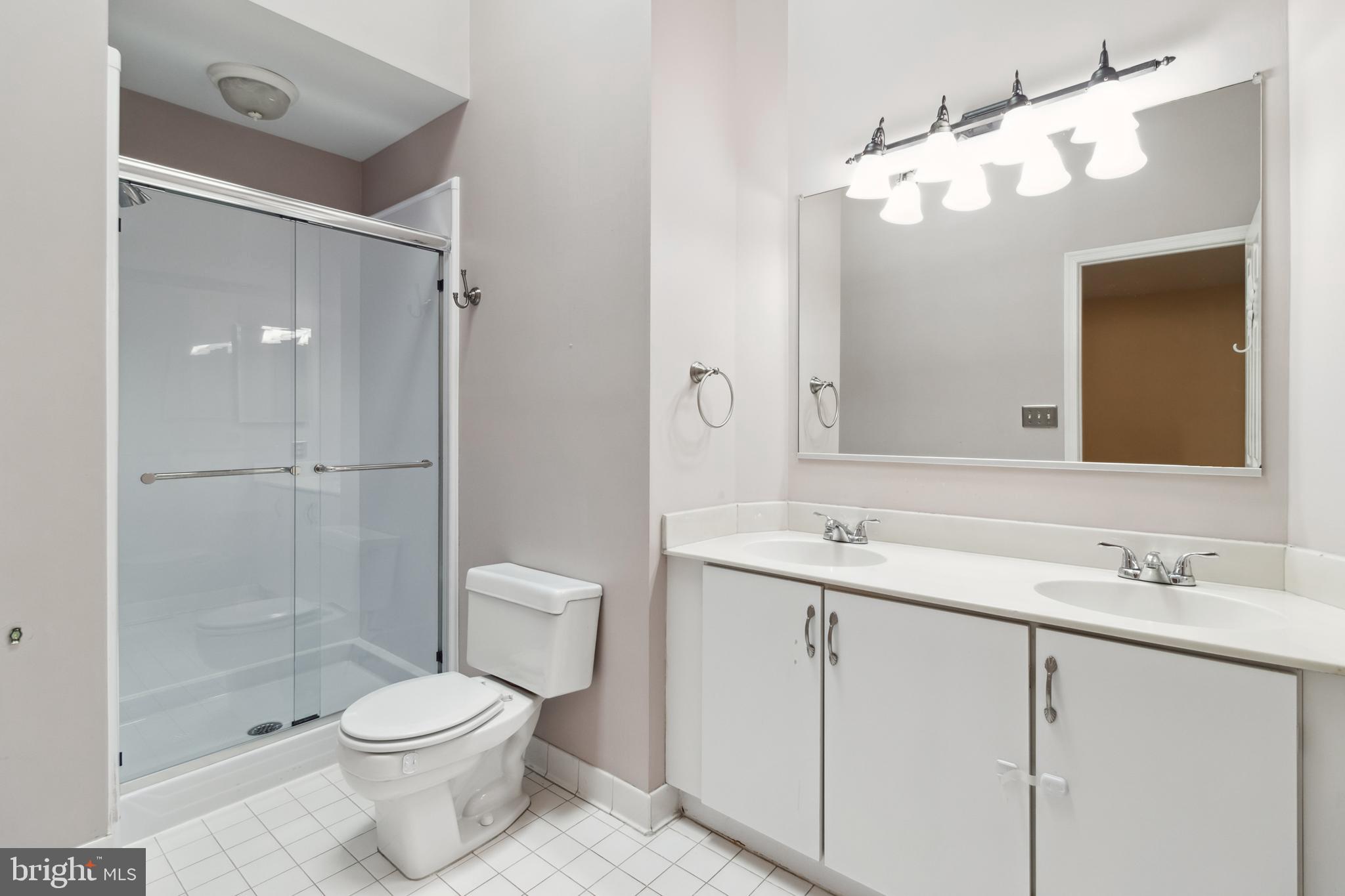 524 Kinsale Road Lutherville-Timonium, MD 21093 - Photo 13 of 22 a bathroom with a toilet a sink a glass door a shower and a mirror