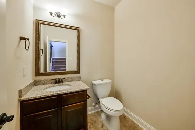 a bathroom with a toilet a sink and mirror