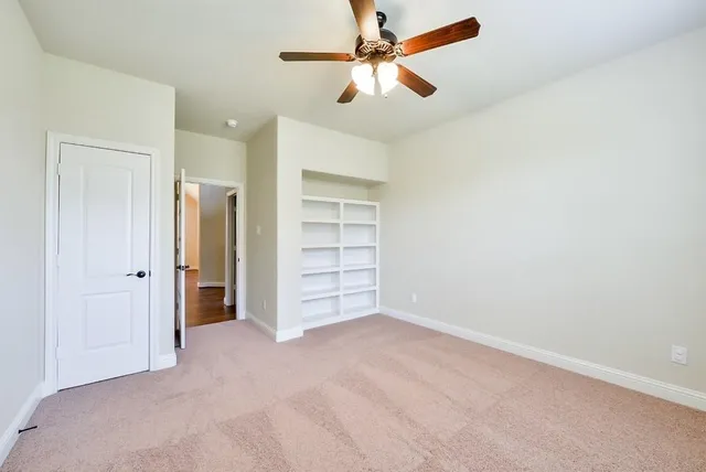 an empty room with closet and fan