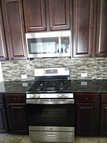 a stove top oven sitting inside of a kitchen
