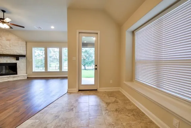 a view of an empty room with window and fire place