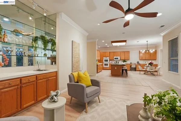 a living room with furniture kitchen view and a large window