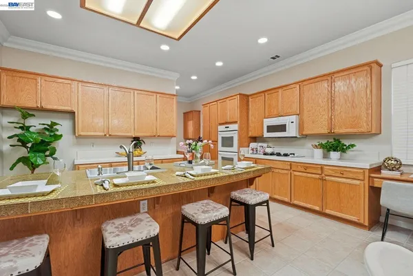 a kitchen with granite countertop sink table and chairs