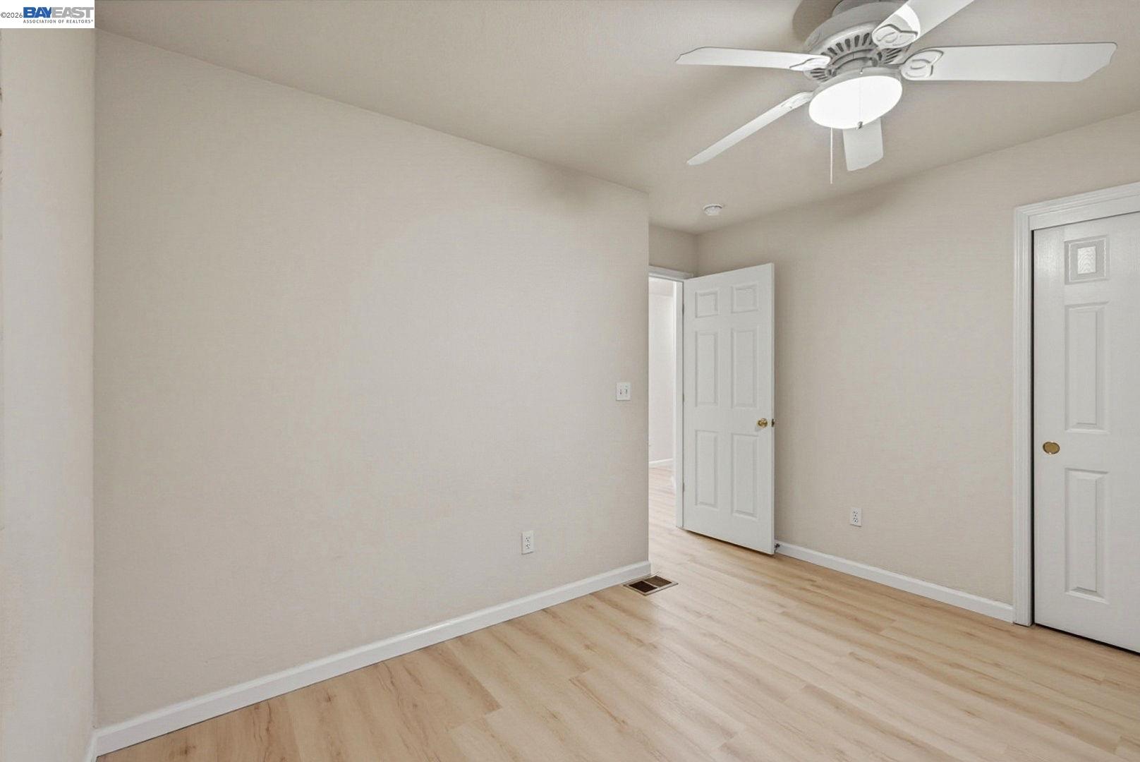 663 Clay Way Ripon, CA 95366 - Photo 30 of 43 an empty room with wooden floor fan and windows