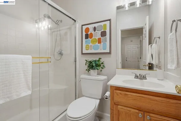 a bathroom with a sink a toilet a shower and a mirror