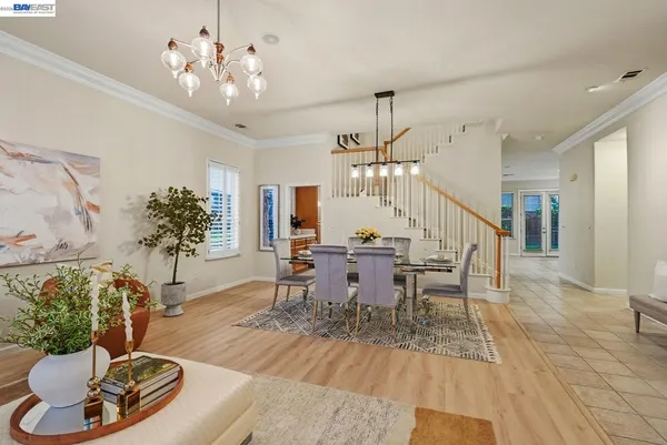 a view of a dining room with furniture a chandelier and wooden floor