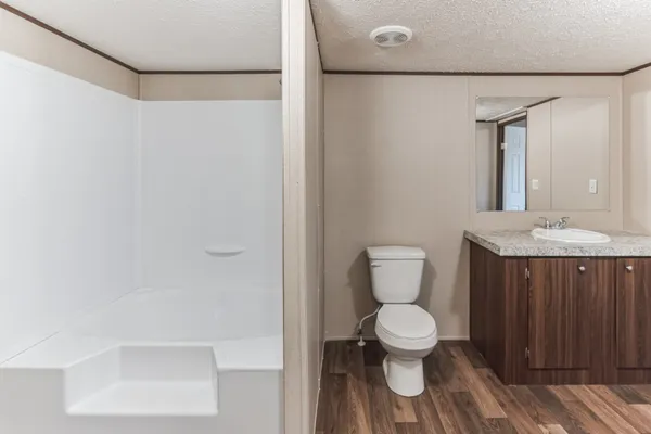 a bathroom with a granite countertop sink toilet and shower