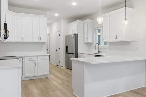 a kitchen with kitchen island white cabinets and refrigerator