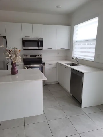 a kitchen with a sink and white cabinets
