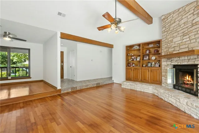 a view of empty room with wooden floor and fireplace