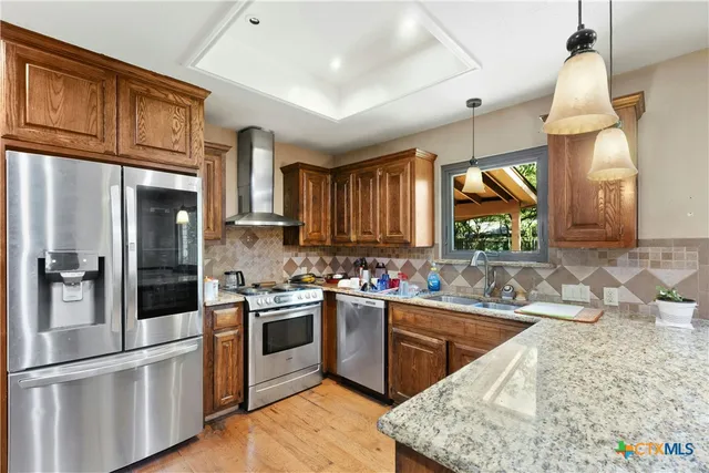 a kitchen with stainless steel appliances granite countertop a sink stove and refrigerator