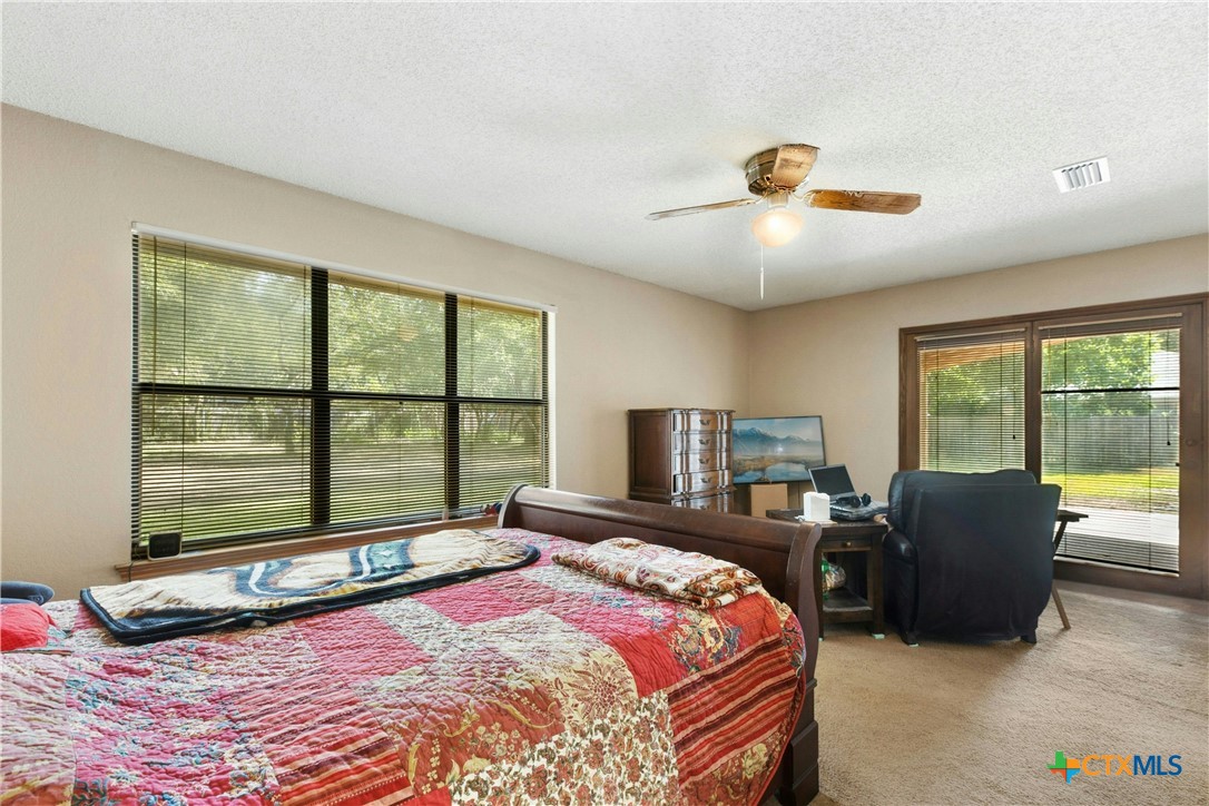 3502 Apache Forest Drive Austin, TX 78739 - Photo 24 of 34 a bedroom with a bed and large windows