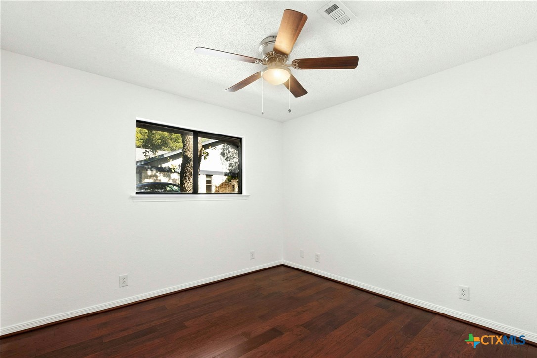 3502 Apache Forest Drive Austin, TX 78739 - Photo 33 of 34 an empty room with wooden floor and ceiling fan