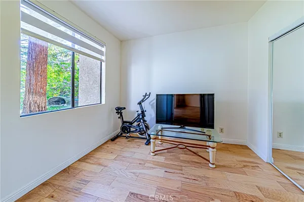 a view of a bedroom with wooden floor and windows