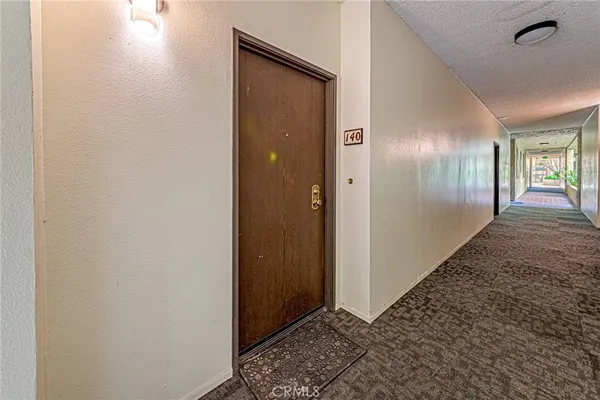 a kitchen with stainless steel appliances granite countertop a refrigerator a stove top oven a sink dishwasher and white cabinets with wooden floor