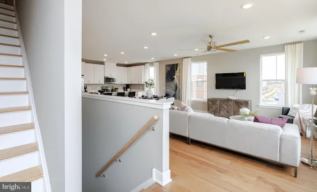 a living room with stainless steel appliances furniture and a flat screen tv