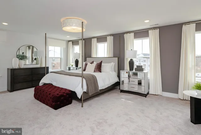 a spacious bedroom with a bed a window and dresser