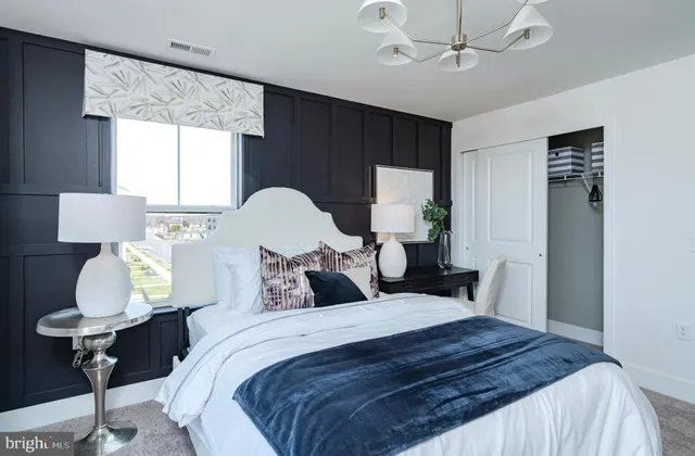 a bedroom with a bed mirror and window