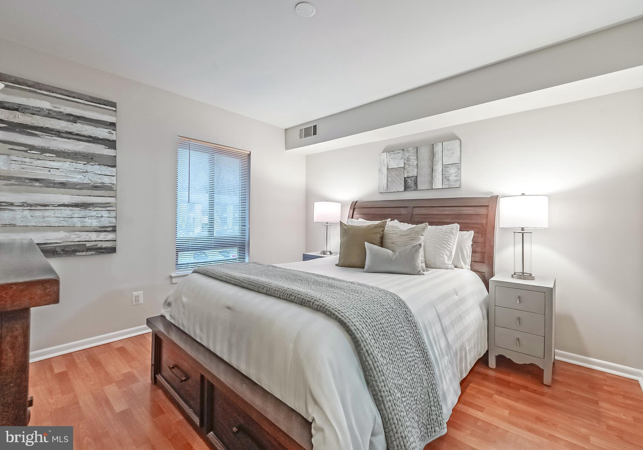 11657 Stoneview Square, Unit 97/22C Reston, VA 20191 - Photo 15 of 28 a bedroom with a bed and wooden floor