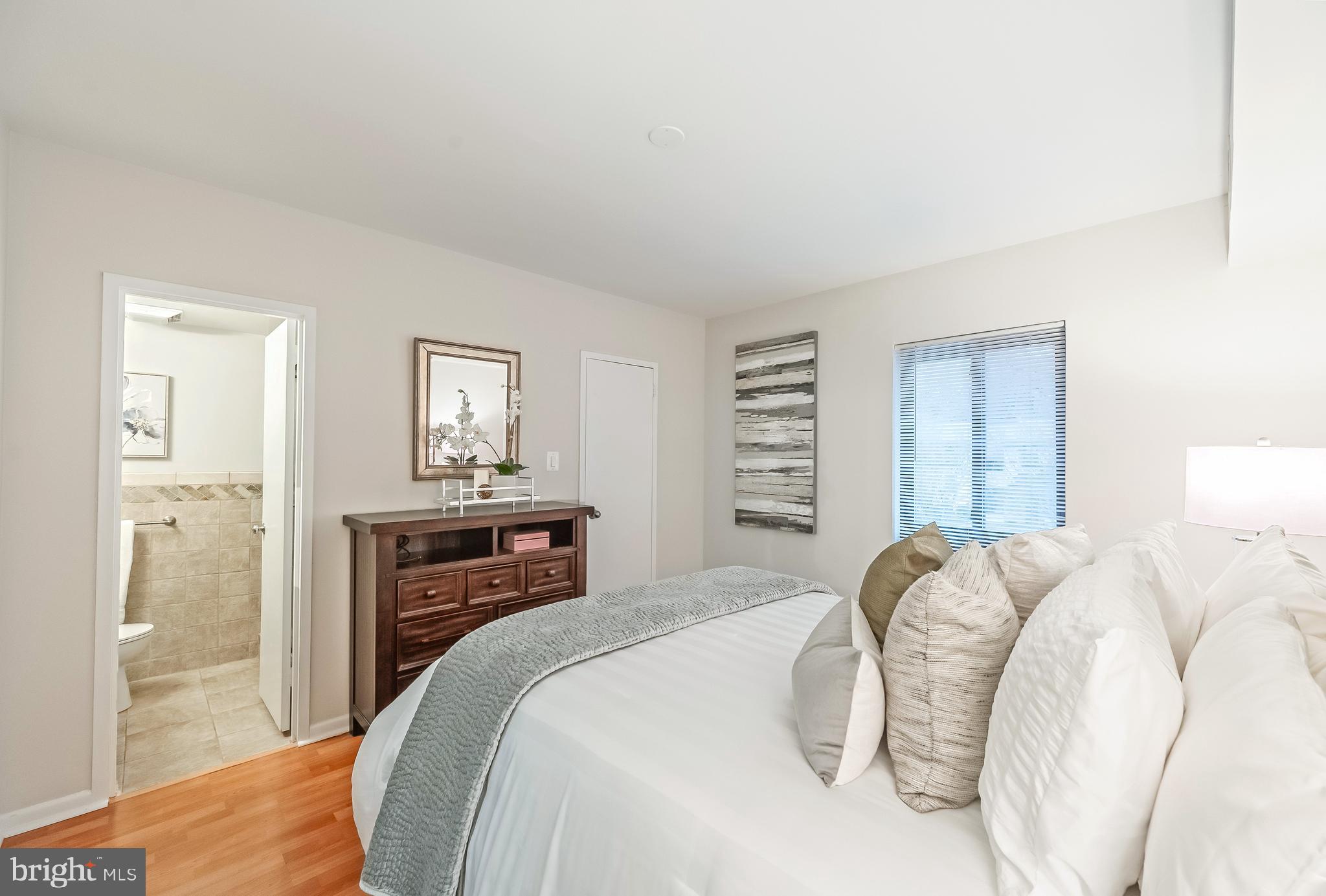 11657 Stoneview Square, Unit 97/22C Reston, VA 20191 - Photo 16 of 28 a bedroom with a bed and a chandelier