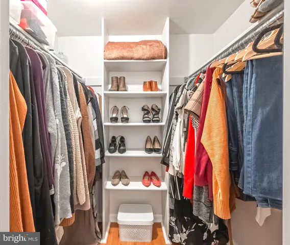 a view of walk in closet with clothes and shoes