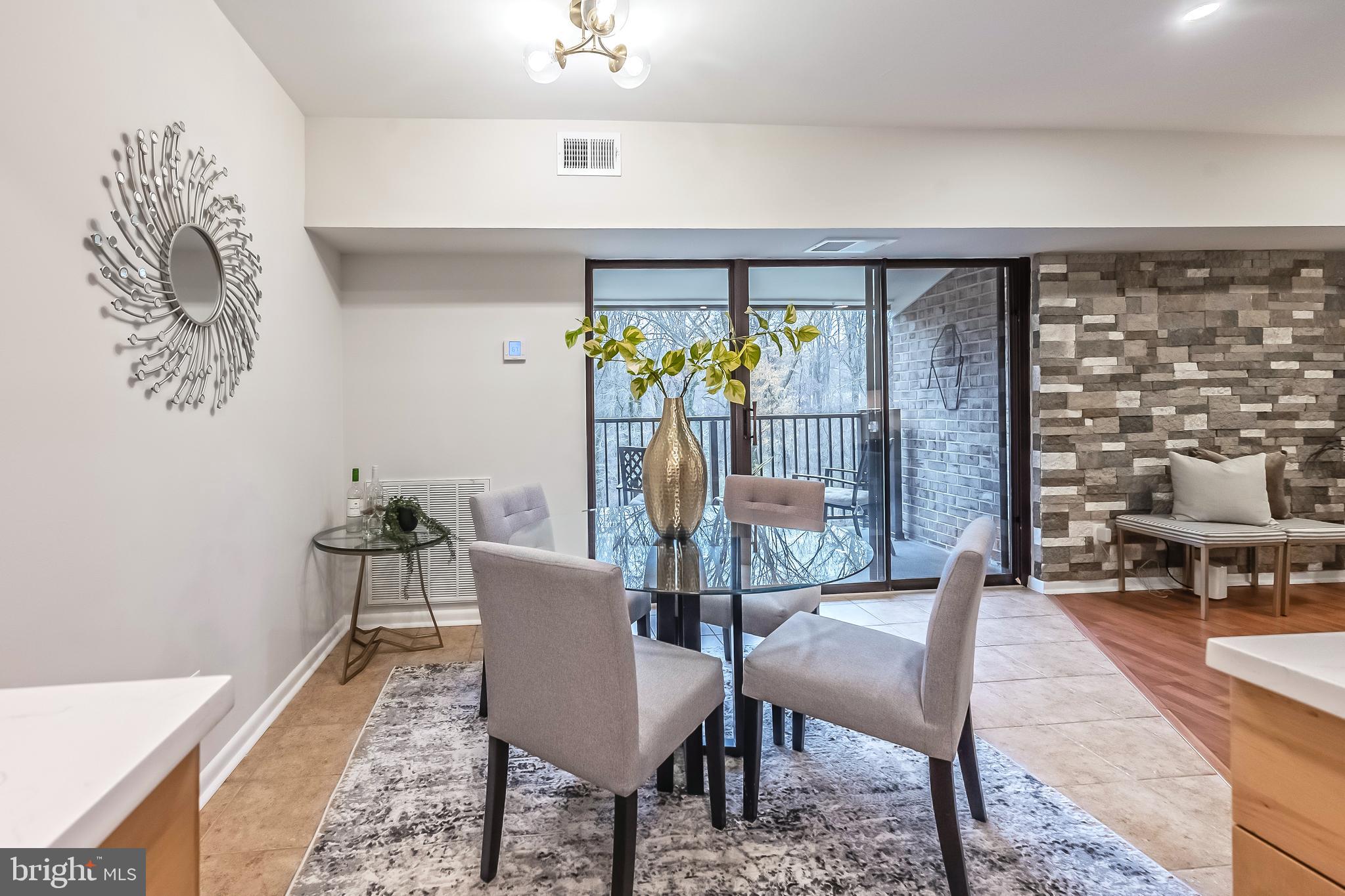 11657 Stoneview Square, Unit 97/22C Reston, VA 20191 - Photo 9 of 28 a dining room with furniture a rug and a floor to ceiling window