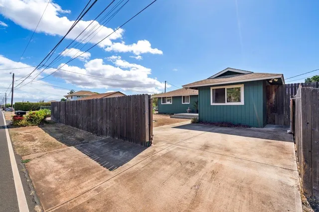 a view of backyard of house with wooden fence
