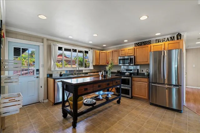 a kitchen with stainless steel appliances granite countertop a refrigerator and a stove top oven