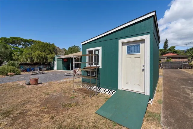 a view of house with yard and sitting area