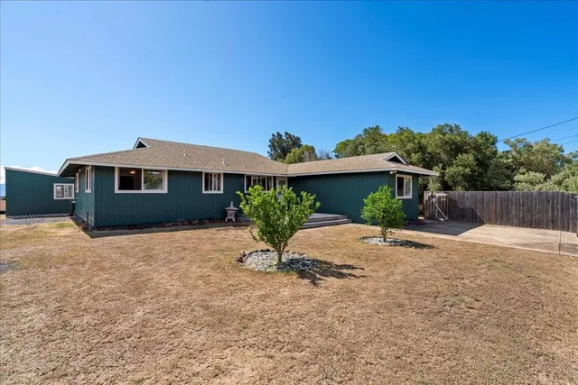 a view of a house with backyard and a garden