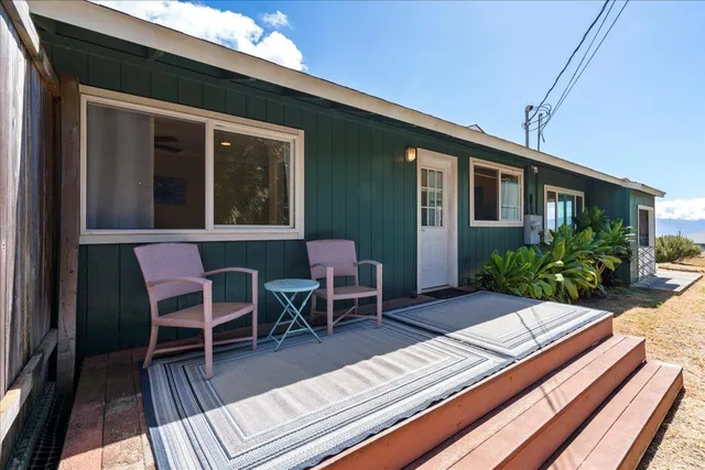 a view of a patio with table and chairs with wooden floor and fence