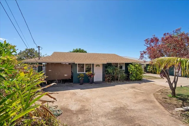 a backyard of a house with table and chairs under an umbrella