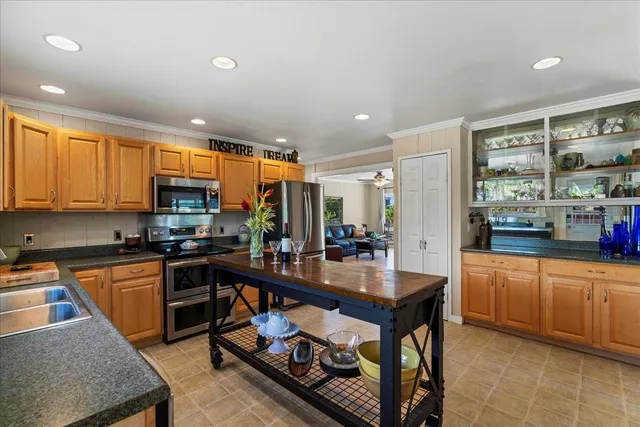 a kitchen with stainless steel appliances granite countertop a stove top oven a sink dishwasher a dining table and chairs with wooden floor