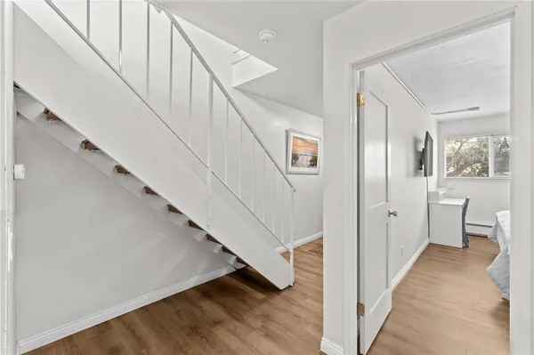 a view of a hallway with white walls and stairs