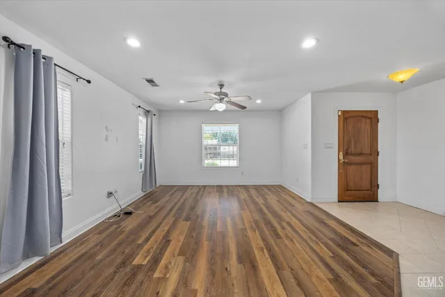 an empty room with a ceiling fan and a window