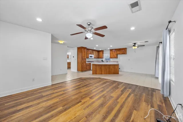 an empty room with a ceiling fan and carpet