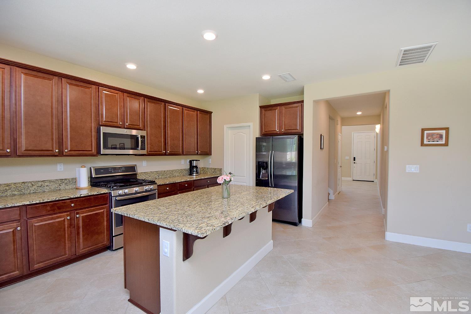 9729 Pachuca Drive Reno, NV 89521 - Photo 12 of 40 a kitchen with a sink refrigerator and microwave