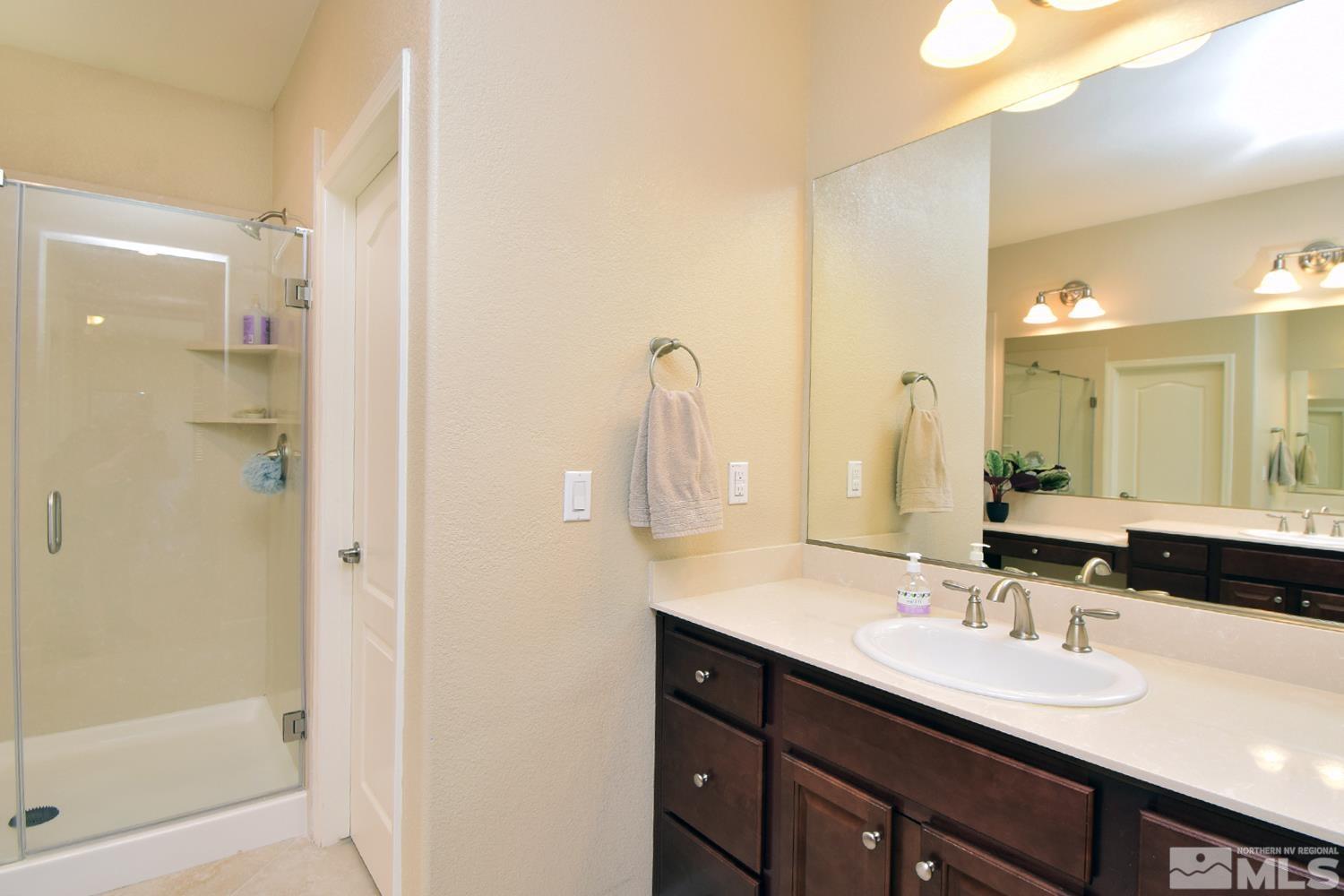 9729 Pachuca Drive Reno, NV 89521 - Photo 26 of 40 a bathroom with a double vanity sink mirror and shower