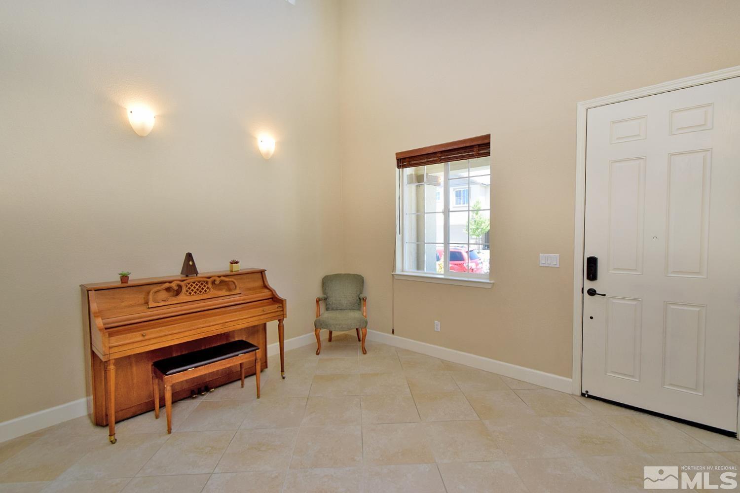 9729 Pachuca Drive Reno, NV 89521 - Photo 4 of 40 a room with a piano and wooden floor