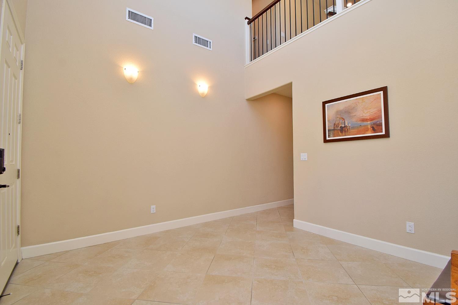9729 Pachuca Drive Reno, NV 89521 - Photo 6 of 40 an empty room with wall painting and refrigerator