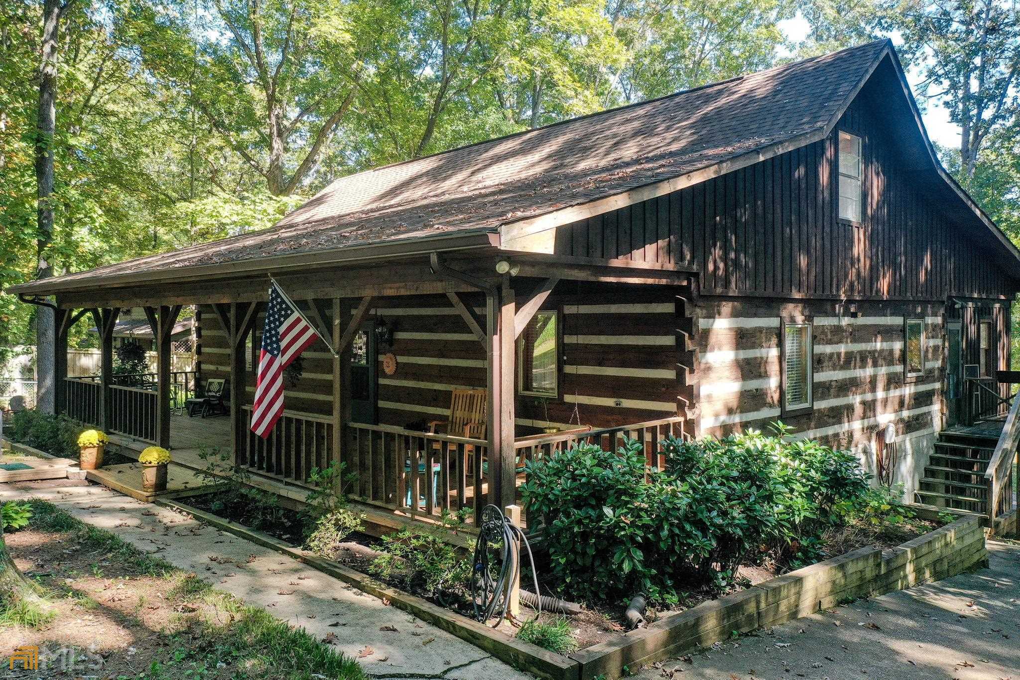 225 Lewis Road Stockbridge, GA 30281 - Photo 1 of 1 a view of small wooden house with a large window and potted plants