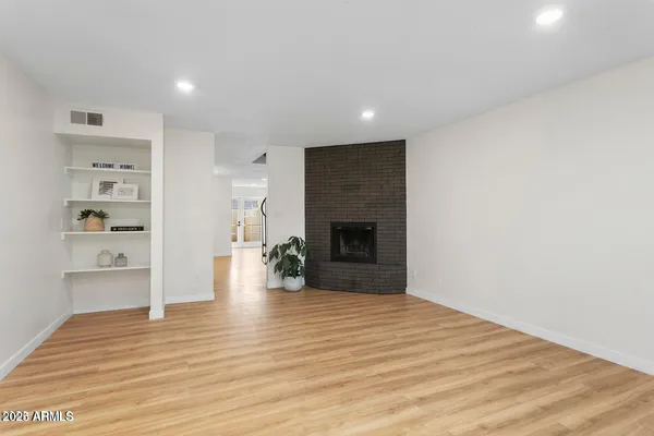 a view of empty room with wooden floor and fireplace